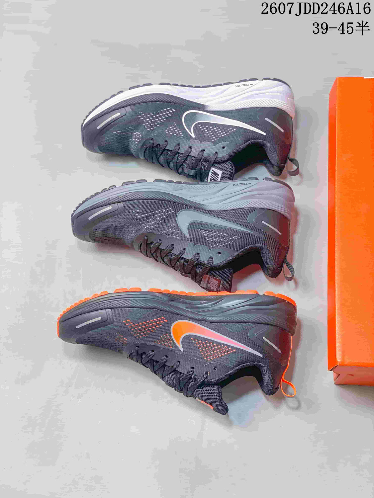 Three views of the sneaker showing dark gray uppers, contrasting Swoosh colors, textured outsoles, and an orange shoe box.