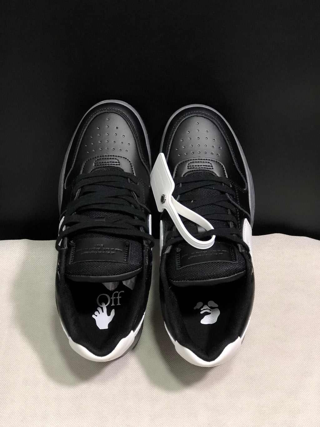 Top view showing black laces, perforated toe boxes, white heel accents, and contrasting insole graphics.