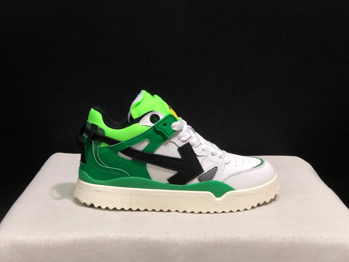 Side profile of a single sneaker showing the white upper, green overlays, black arrow, and textured cream outsole.