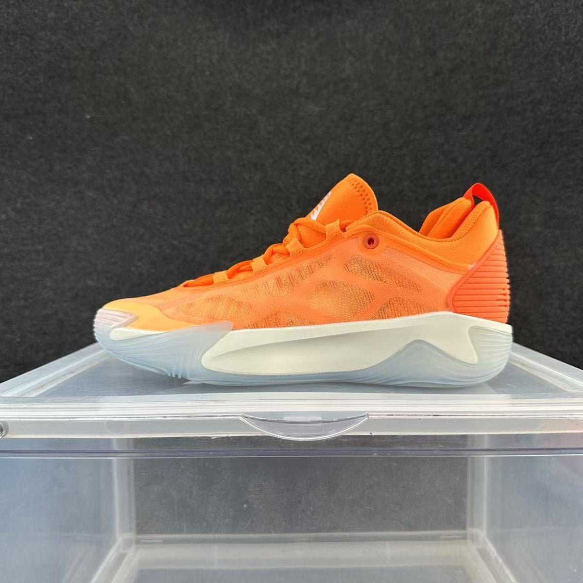 Bright orange low-top basketball shoe with a white sculpted sole