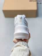 Rear view of a white sneaker showing the padded collar, heel pull tab and thick raised sole.