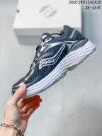 Side profile of the dark Saucony sneaker showing the mesh-look upper, layered side branding and white midsole.