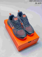 Pair of dark gray and orange Nike running sneakers displayed on an orange shoebox.