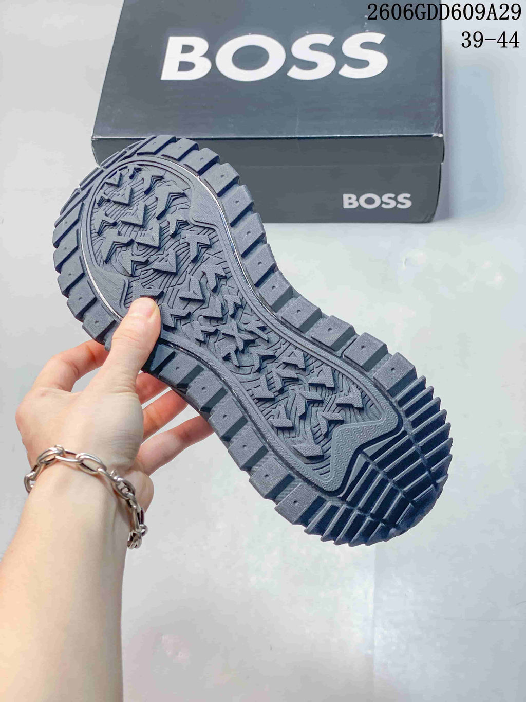 Close-up of the gray sneaker outsole showing its deep patterned tread.