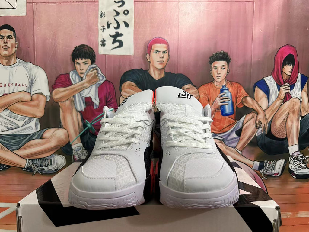 Front view of white lace-up basketball shoes with red accents