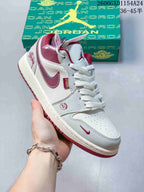 Angled view of an Air Jordan 1 Low with burgundy graphics and a decorative charm