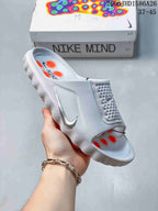 Angled view of the white slide sandal with orange footbed and outsole accents