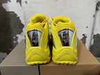Rear view of yellow sneakers with reflective silver-tone heel details.