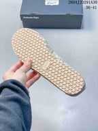 Close-up of the textured geometric outsole on a cream sneaker.