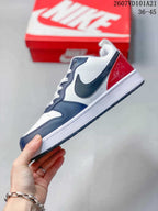 Side profile showing the white upper, navy overlays, dark Swoosh and red heel detail.