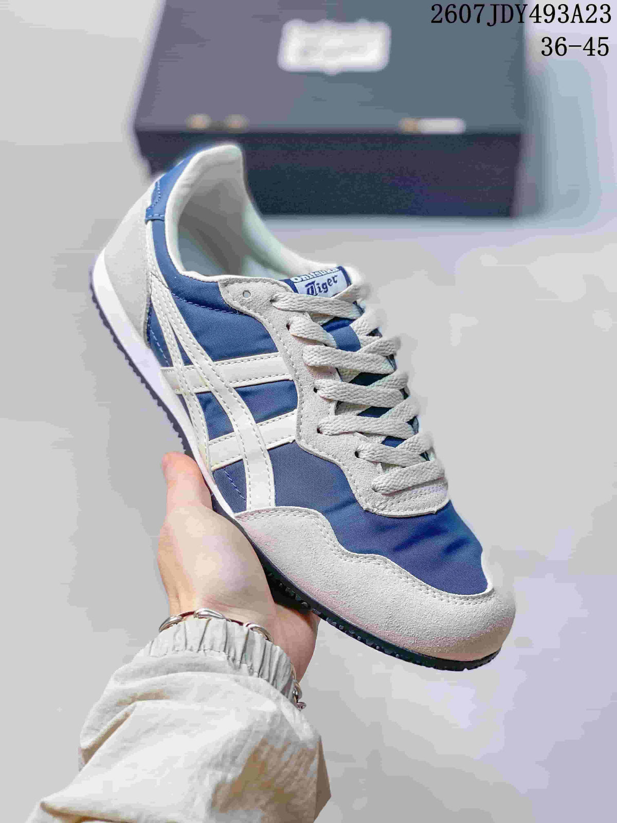Close side view of a blue and white Onitsuka Tiger Serrano sneaker.