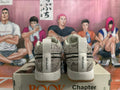 Rear view of gray patterned Nike Book 1 sneakers with white heel tabs and gum-colored outsoles, displayed on a shoe box.