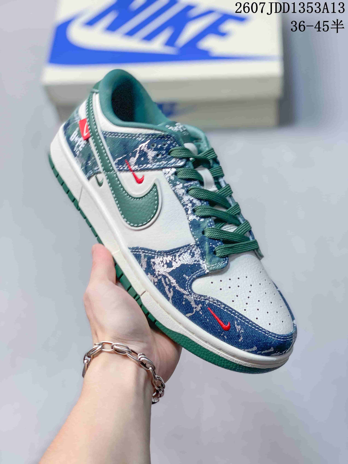 Angled side view showing the blue patterned upper, white toe panel, green Swoosh and green outsole.
