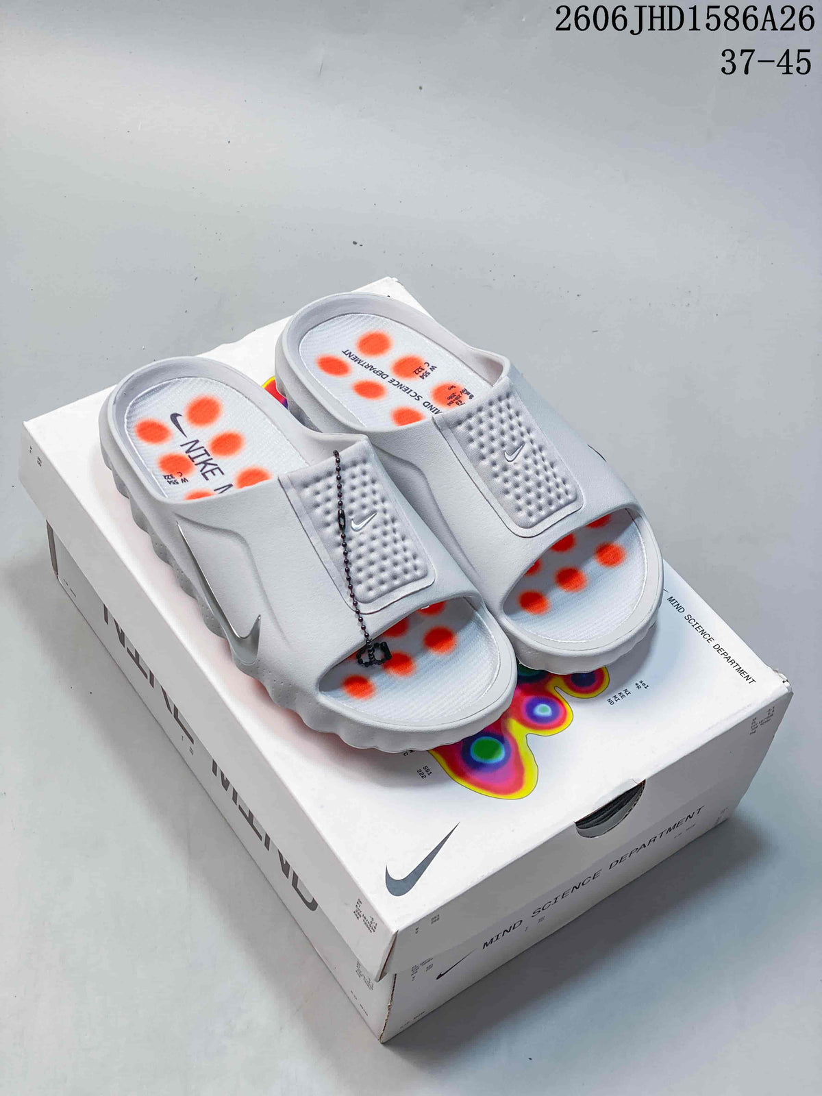 Pair of white Nike Mind slide sandals with orange details on a Nike Mind box