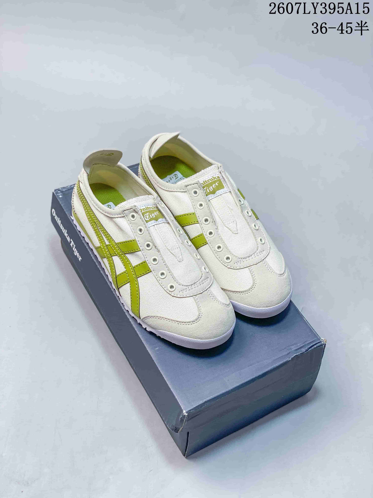 Pair of white and green Onitsuka Tiger Mexico 66 Deluxe sneakers displayed on a branded shoe box.