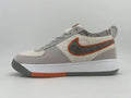 Gray and off-white Nike low-top sneaker with an orange-outlined side Swoosh and orange sole accent