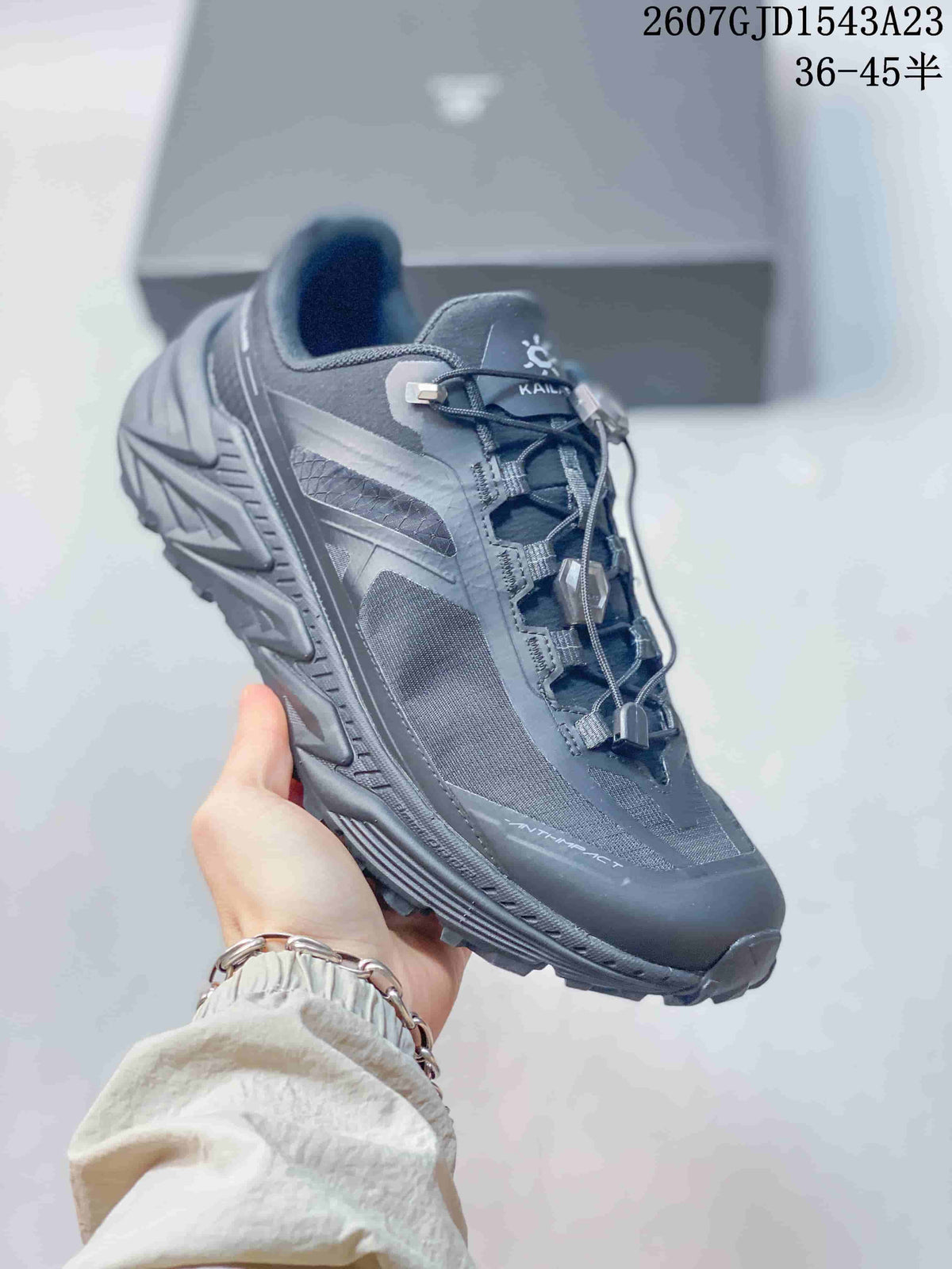 Angled side view showing the dark gray upper, mesh panels, protective toe cap, and textured outsole.
