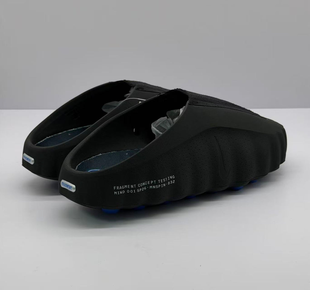 Rear three-quarter view showing the open heel, blue outsole pods and printed side text.