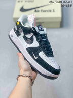 Angled side view of the black and white Nike Air Force 1 sneaker showing embroidered Swoosh details, dark textured overlays, and white midsole.