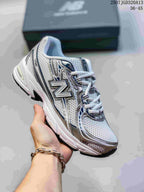Angled side view showing the white, silver, and navy upper with the New Balance logo.