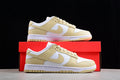 Pair of white and pale cream Nike SB low-top sneakers displayed with a red shoebox.