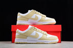 Pair of white and pale cream Nike SB low-top sneakers displayed with a red shoebox.