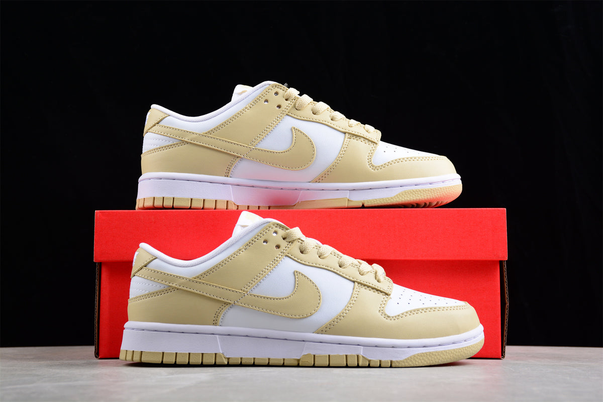 Pair of white and pale cream Nike SB low-top sneakers displayed with a red shoebox.