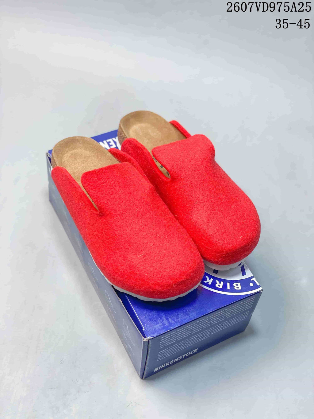 Red closed-toe Amsterdam clogs displayed on a blue Birkenstock box; source overlay shows code 2607VD975A25 and size range 35-45.