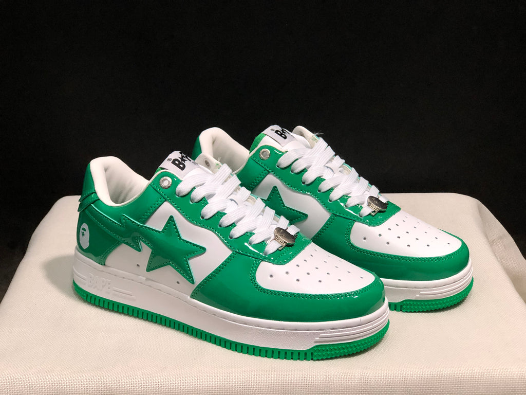 Three-quarter view of the white and green pair showing the star side graphics, white midsoles, and green outsoles.