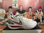 Side view of a white Nike basketball sneaker showing the perforated upper, red-accented Swoosh, multicolor heel panel and red midsole insert.