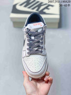 Top view showing the perforated off-white toe box, patterned laces, tongue, and dark lining.