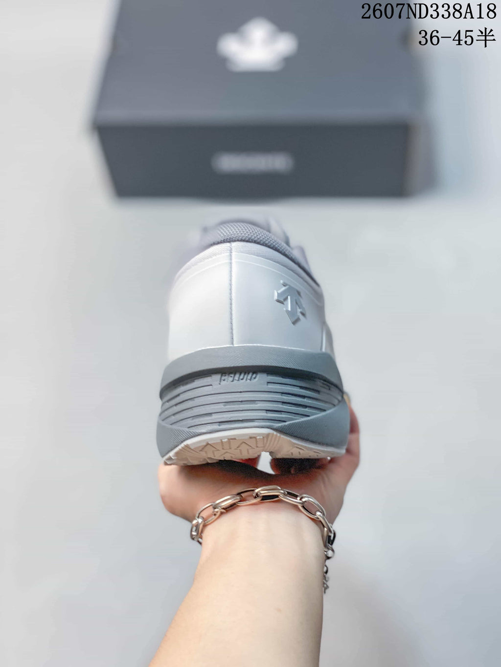 Rear view of the white and gray sneaker showing the padded heel and layered outsole construction.