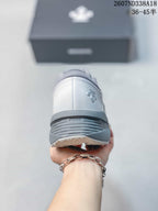 Rear view of the white and gray sneaker showing the padded heel and layered outsole construction.