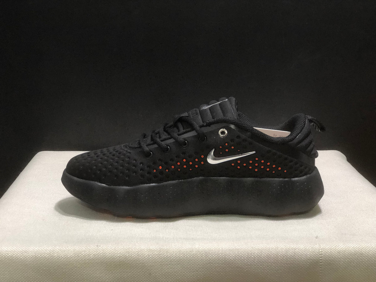 Side profile of a black sneaker showing its thick sculpted black outsole and perforated upper.