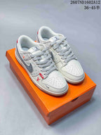 Pair of white, gray, and red low-top sneakers displayed on an orange shoebox; visible overlay shows style code 2607ND1602A12 and size range 36–45.