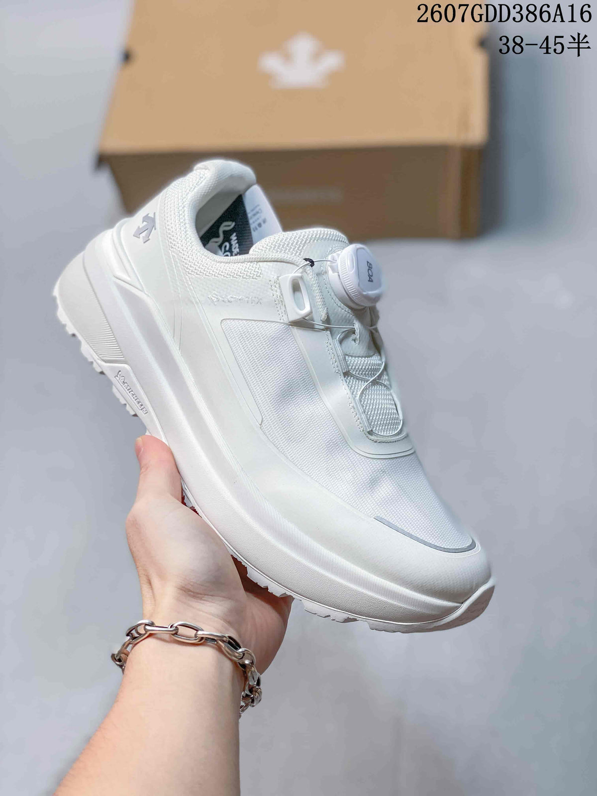 Angled side view of a white DESCENTE sneaker showing the textured upper, BOA dial, layered sole, and visible model detailing.