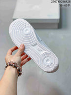 Bottom view of a white sneaker showing the circular traction pattern and textured rubber outsole.