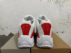 Rear view of white sneakers with red heel panels and chunky outsoles