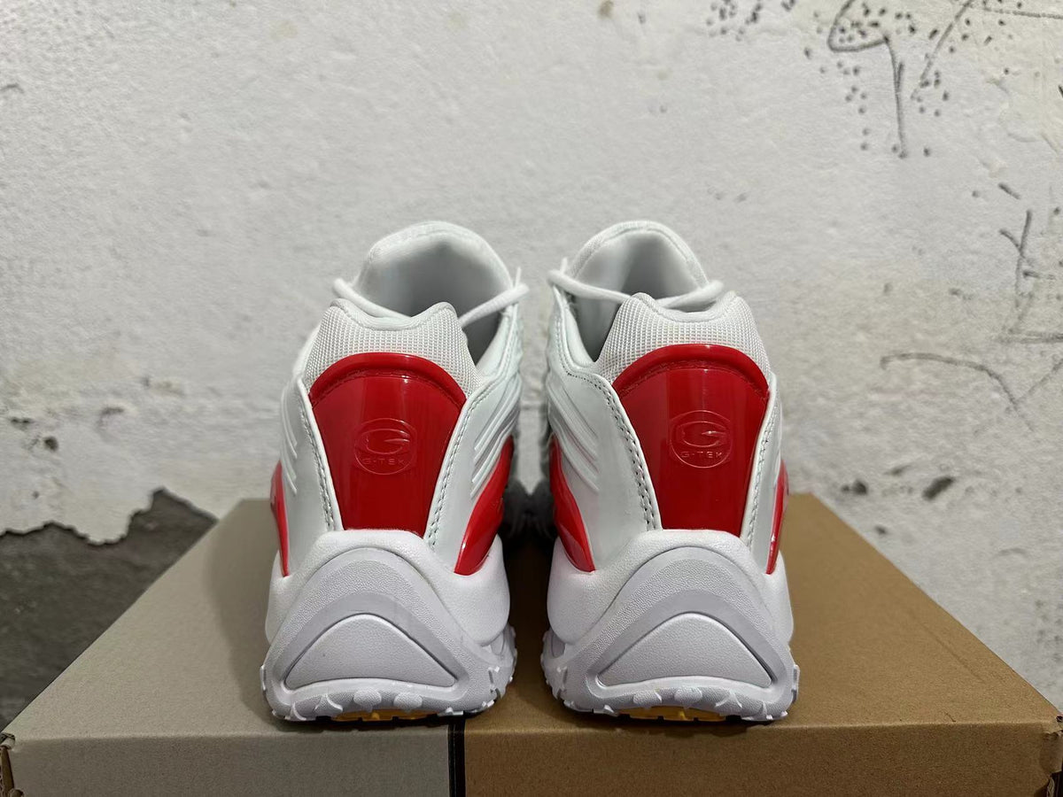 Rear view of white sneakers with red heel panels and chunky outsoles