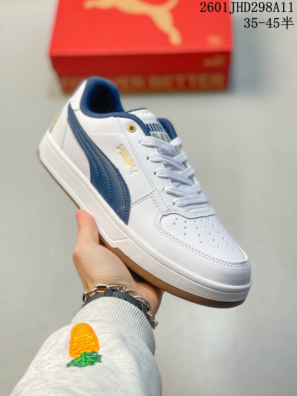 Angled side view showing the white upper, navy side stripe, gold eyelets and gum-toned outsole.