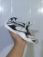 Side view of a white and black Radar sneaker showing the layered upper, mesh panels and textured outsole.