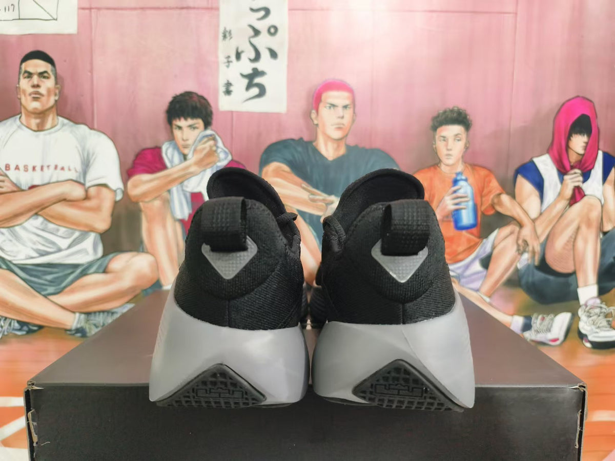 Rear view of black and grey Nike sneakers showing heel pull tabs and outsole details