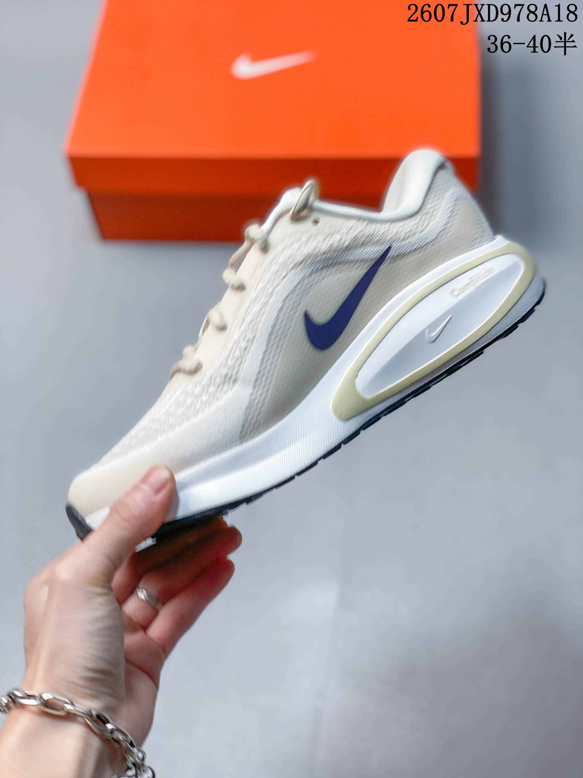 Side view of the white sneaker showing the purple Swoosh, mesh upper, and layered heel sole.