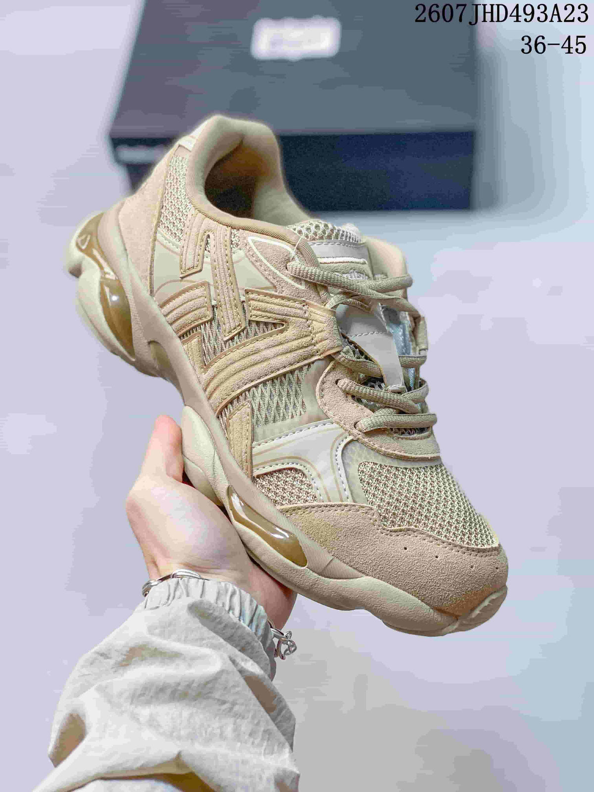 Three-quarter front view highlighting the layered retro running-shoe design in beige and cream.