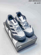 Pair of white, black and gray Adidas Terrex hiking shoes displayed on a Terrex shoe box.
