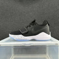 Side view of a black Nike basketball shoe with a forefoot strap, white speckled midsole, and light blue outsole.