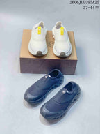 White and dark gray pairs of Galah slip-on shoes shown together.