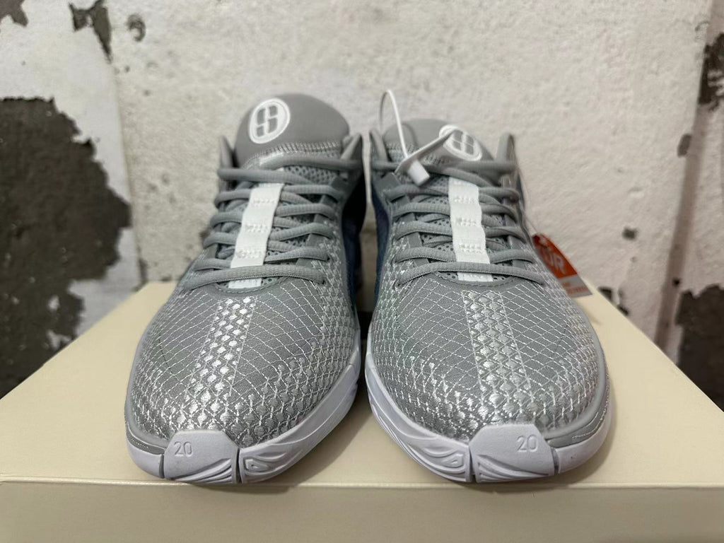 Front view of grey Nike basketball shoes with patterned toes, grey laces, and white outsole details.