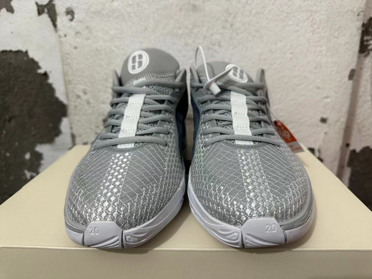 Front view of grey Nike basketball shoes with patterned toes, grey laces, and white outsole details.