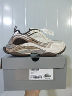 Side view of Balenciaga Triple S 2 2290 sneakers in brown, beige, white, and grey, displayed on the labeled shoe box.